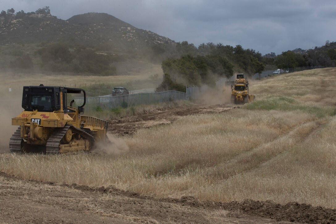 Camp Pendleton Fire Department, CAL Fire, and Orange County firefighters excavate fire breaks along the highway during joint operations at Marine Corps Base Camp Pendleton, California, April 30, 2018. The goal was to establish 38 miles of a total of 164 miles of firebreaks used to keep fires from leaving the installation and damaging property on and off base for the rest of the fire season. (U.S. Marine Corps photo by Lance Cpl. Drake Nickels)