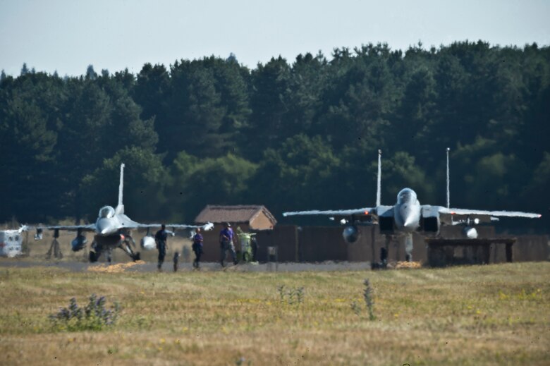 An F-15C Eagle from the 48th Fighter Wing's 493rd Fighter Squadron, and an F-16C Fighting Falcon from the 31st Fighter Wing's 510th Fighter Squadron prepare to take off for a training sortie at Royal Air Force Lakenheath, England, Aug. 3, 2018. The 501th FS "Buzzards" completed a two-week flying training deployment to the United Kingdom Aug. 6, 2018. (U.S. Air Force photo by Master Sgt. Eric Burks)