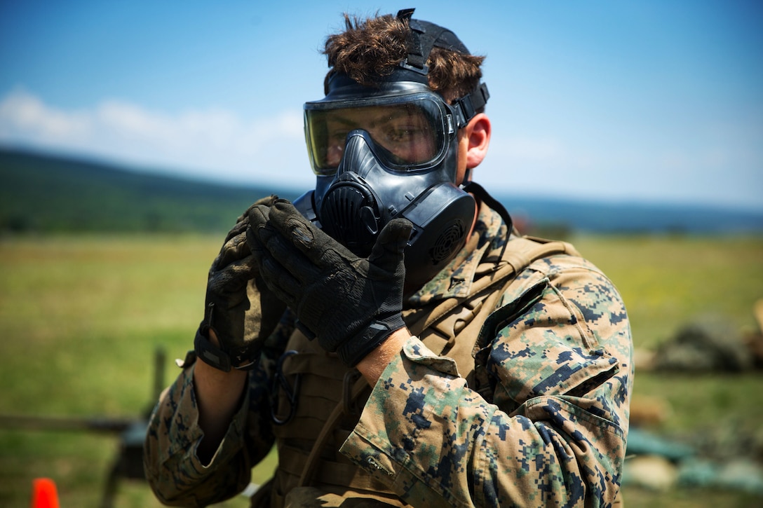 A Marine ensures is mask in put on properly.