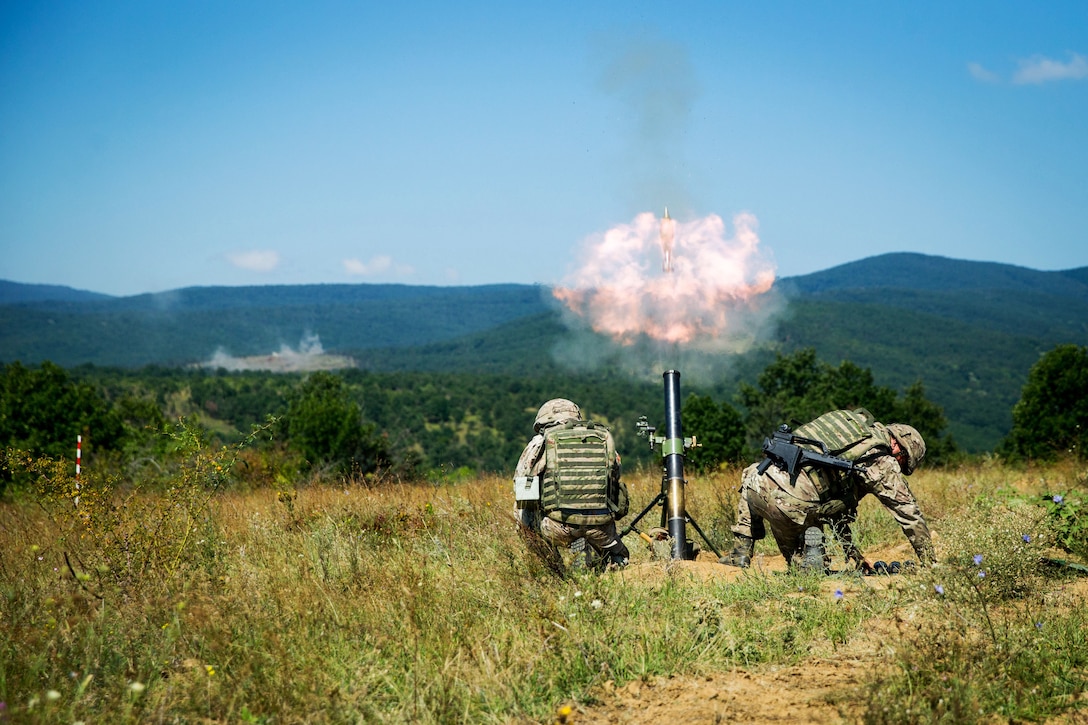 Montenegrin soldiers fire an 81 mm mortar after getting instructions from Marines.