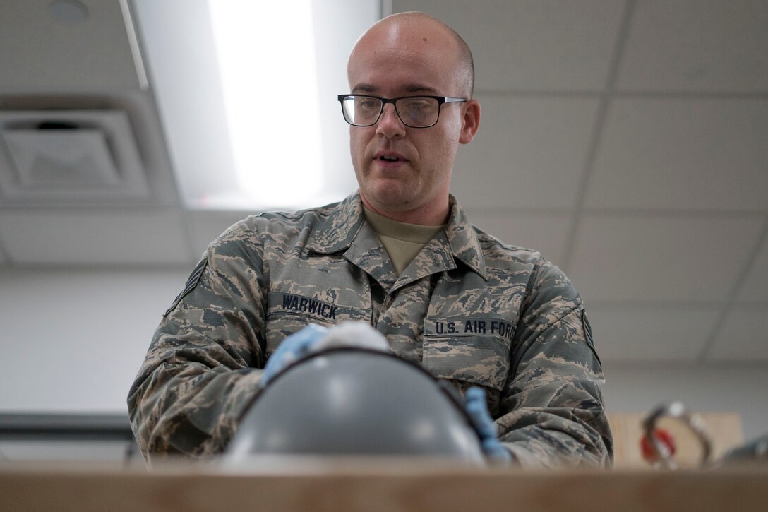 Staff Sgt. Miles Warwick inspects aircrew flight equipment.