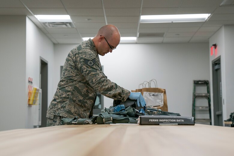 Staff Sgt. Miles Warwick inspects aircrew flight equipment.