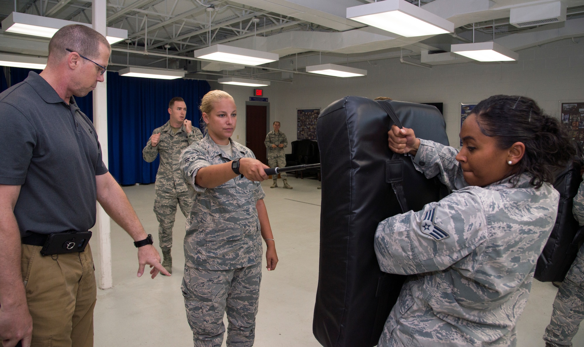 U.S. Air Force Airman 1st Class Casey Atanasio, center, a patient travel coordinator assigned to the 6th Medical Support Squadron, learns proper distance and form for baton strikes at MacDill Air Force Base, Fla., July 25, 2018.