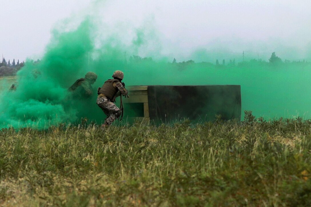 Georgian troops assault on a simulated enemy position under the cover of smoke.