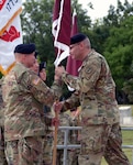Brig. Gen. Jeffrey J. Johnson (right), commanding general of U.S. Army Regional Health Command-Central, passes the unit colors to Command Sgt. Maj. Joseph L. Cecil during an assumption of command ceremony at the U.S. Army Medical Museum Amphitheatre at Joint Base San Antonio-Fort Sam Houston Aug. 6.