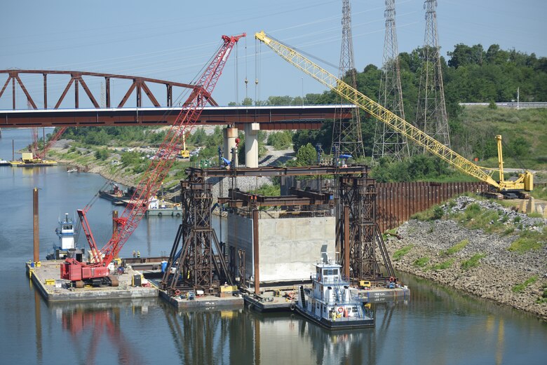 A tow boat pulls out a barge after a gantry crane picked up a 1.3 million pound concrete shell Aug. 3, 2018 downstream of Kentucky Lock in Grand Rivers, Ky. The U.S. Army Corps of Engineers Nashville District and contractor, Johnson Brothers, were preparing to place it on the riverbed where it will be part of a coffer dam and eventually a permanent part of the new lock wall for the Kentucky Lock Addition Project. An issue with the strand jack delayed the placement of the concrete shell until Aug. 6. It is the first of 10 shells being placed over the next year. The lock is located at Kentucky Dam, which is a Tennessee Valley Authority project at Tennessee River mile 22.4. (USACE Photo by Lee Roberts)