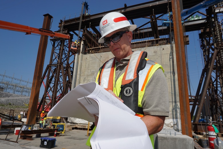Barney Schulte, technical engineer for Kentucky Lock Addition Project, checks specifications for the gantry crane lift system in preparation for the movement of a 1.3 million pound concrete shell Aug. 4, 2018 into the downstream riverbed to form a cofferdam.  The shell will also be part of the permanent lock wall. (USACE Photo/Mark Rankin)