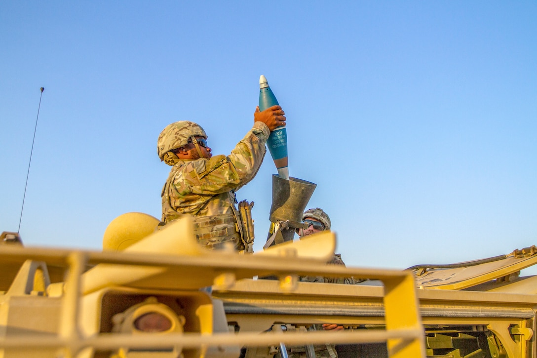 A soldier loads a mortar.