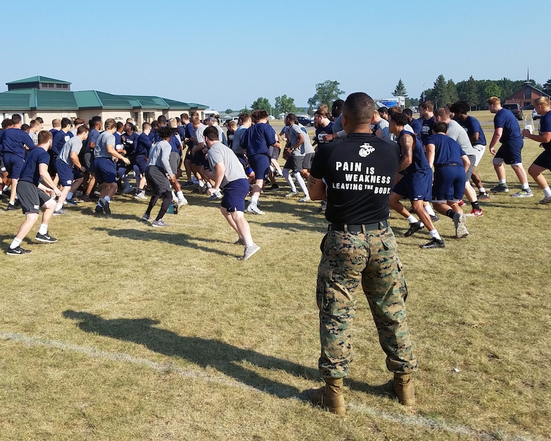 Gunnery Sgt. Joseph Ferguson, the logistics chief of Marine Corps Recruiting Station Twin Cities, leads a Leadership and Cohesion Exercise physical training event with 100 student athletes from the Concordia University football team, 8 August, 2018, at Camp Ripley in Little Falls, Minn. The exercise, led by the Minneapolis Officer Selection Team, challenged the players to push themselves past their comfort zone and taught them about the leadership ethos engrained within the Marine Corps while helping them to grow stronger as a team. (Courtesy photo)