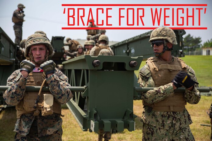 Lance Cpl. Michael Braceland, left, and Seaman Ignacio Munguia, right, lift up part of a medium girder bridge during a multi-level bridging operation Aug. 9, 2018 at Camp Hansen, Okinawa, Japan. Marines with Bridge Company, 9th Engineer Support Battalion, 3rd Marine Logistics Group and Sailors with Naval Mobile Construction Battalion 5 assembled and disassembled a medium girder bridge, which is used to transport personnel and equipment over large gaps and bodies of water. Braceland, a combat engineer with Bridge Co., 9th ESB, is a native of Needham, Massachusetts. Munguia, a construction electrician constructionman with NMCB 5, is a native of Corona, California. (U.S. Marine Corps photo by Pfc. Terry Wong)