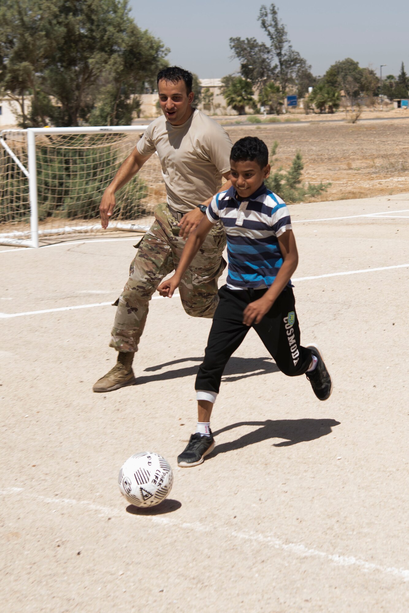 332nd Air Expeditionary Wing Airmen play soccer with local kids at an undisclosed location in Southwest Asia May 26, 2018. (U.S. Air Force photo by Senior Airman Krystal Wright)