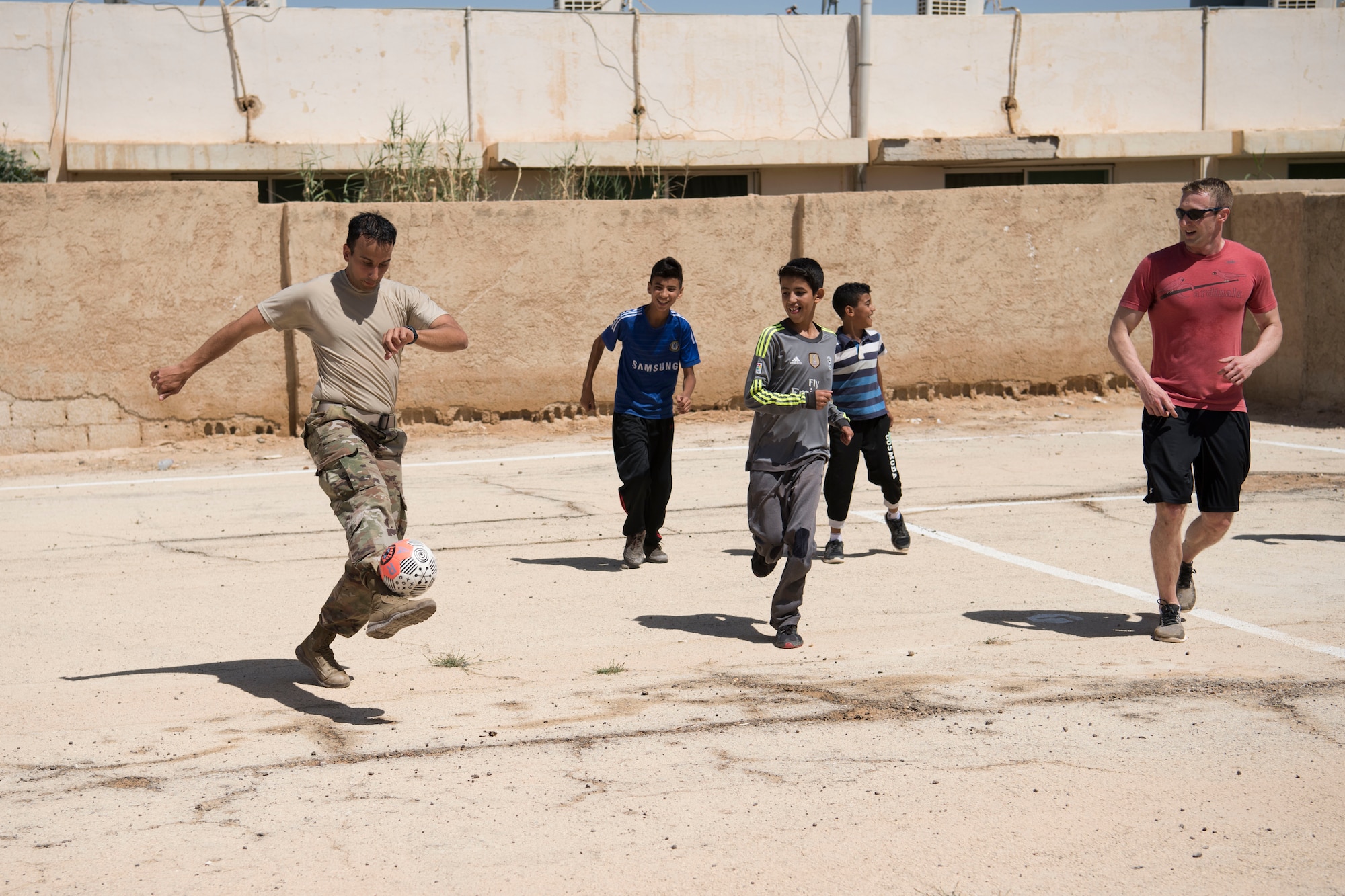 332nd Air Expeditionary Wing Airmen play soccer with local kids at an undisclosed location in Southwest Asia May 26, 2018. (U.S. Air Force photo by Senior Airman Krystal Wright)