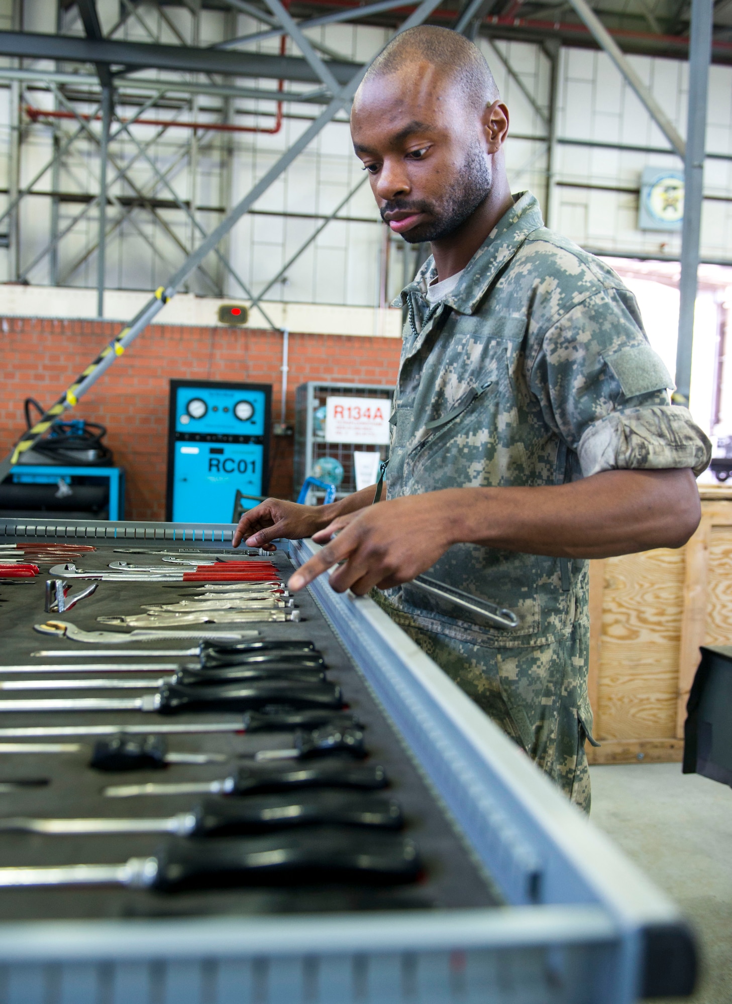 U.S. Air Force Senior Airman Lamar Cotton, 100th Maintenance Squadron aerospace ground equipment journeyman, looks for his next tool while working on a diesel generator at RAF Mildenhall, England, May 8, 2018. Aerospace ground equipment Airmen maintain a variety of essential equipment such as generators, heaters and flood lights, which are essential for crew chiefs and other flightline Airmen to do their jobs and keep the mission going. (U.S. Air Force photo by Airman 1st Class Alexandria Lee)