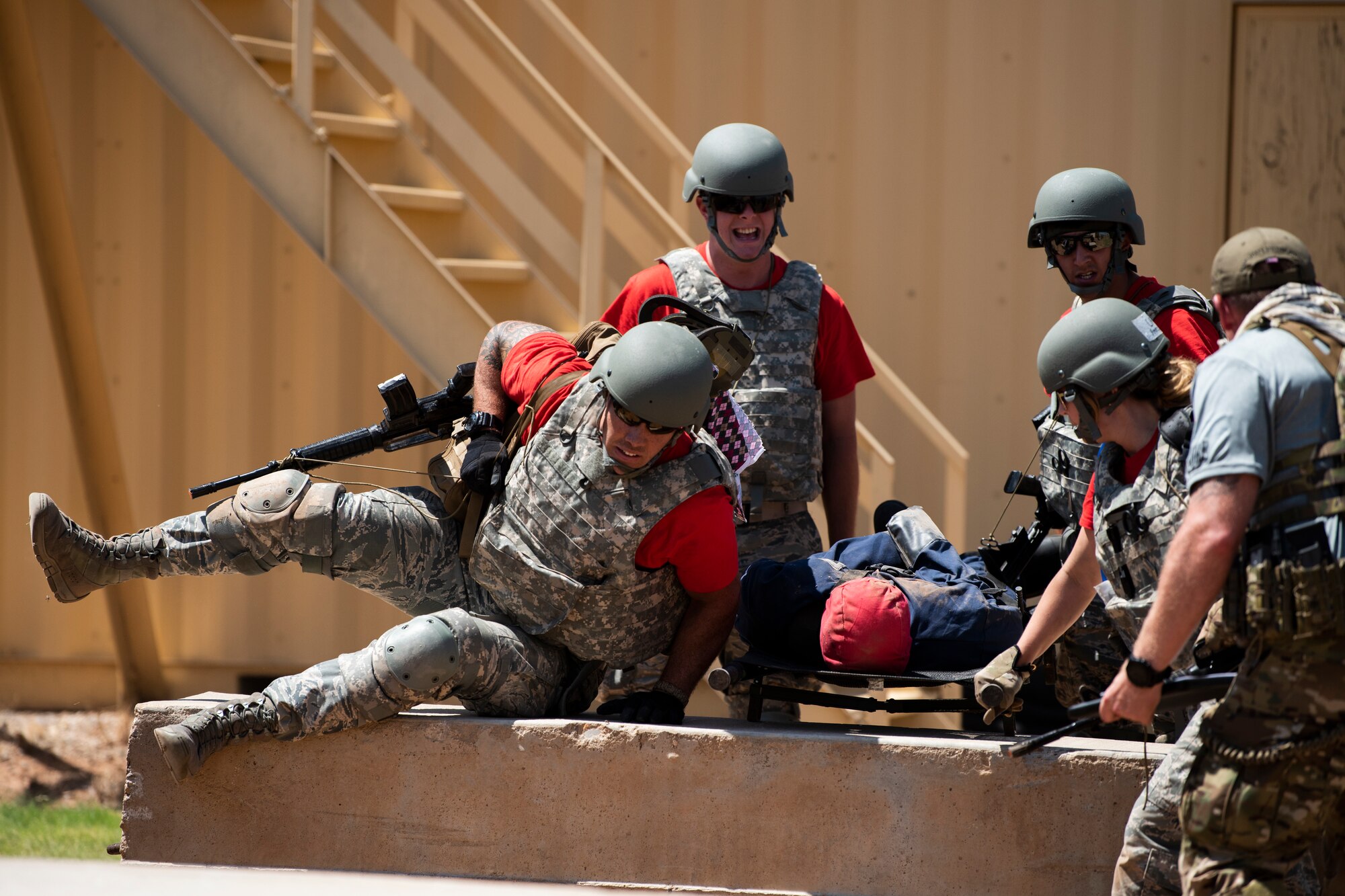 Medical technicians from Otis Air National Guard Base, Mass., lift a mannequin over a barrier at the Emergency Medical Technician Rodeo at Melrose Air Force Range, N.M., August 8, 2018. A total of 21 Air Force bases from around the world visited MAFR and Cannon Air Force Base, New Mexico, to participate in the EMT Rodeo, giving the technicians a wide assortment of scenarios to test their knowledge and training in the medical field. (U.S. Air Force photo by Airman 1st Class Gage Adison Daniel)