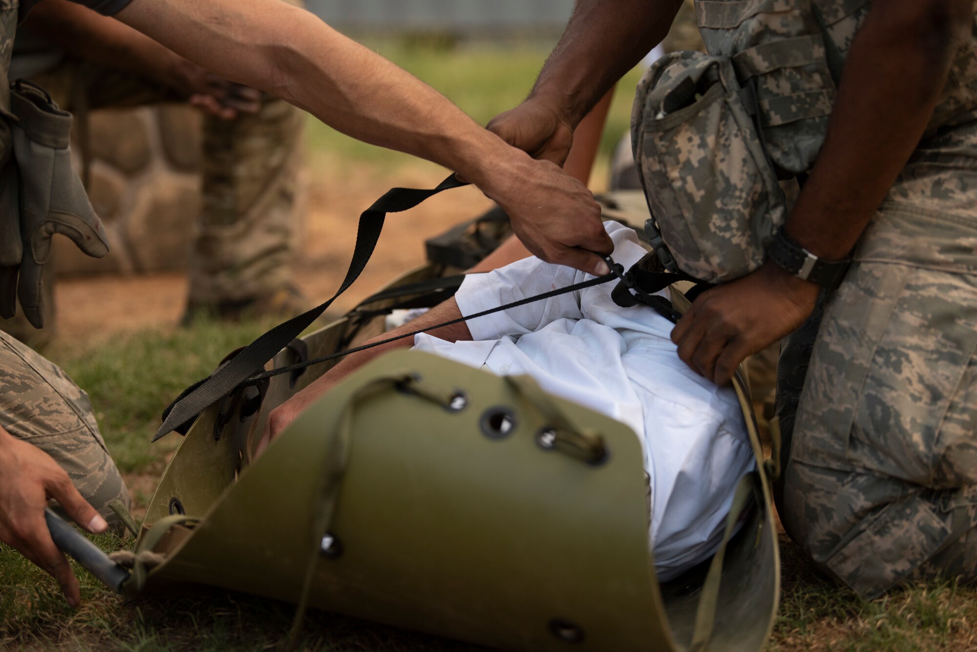 An Airman fastens a strap around a simulated victim at the Emergency Medical Technician Rodeo at Melrose Air Force Range, N.M., August 8, 2018. A total of 21 Air Force bases from around the world visited MAFR and Cannon Air Force Base, New Mexico, to participate in the EMT Rodeo, giving the technicians a wide assortment of scenarios to test their knowledge and training in the medical field. (U.S. Air Force photo by Airman 1st Class Gage Adison Daniel)