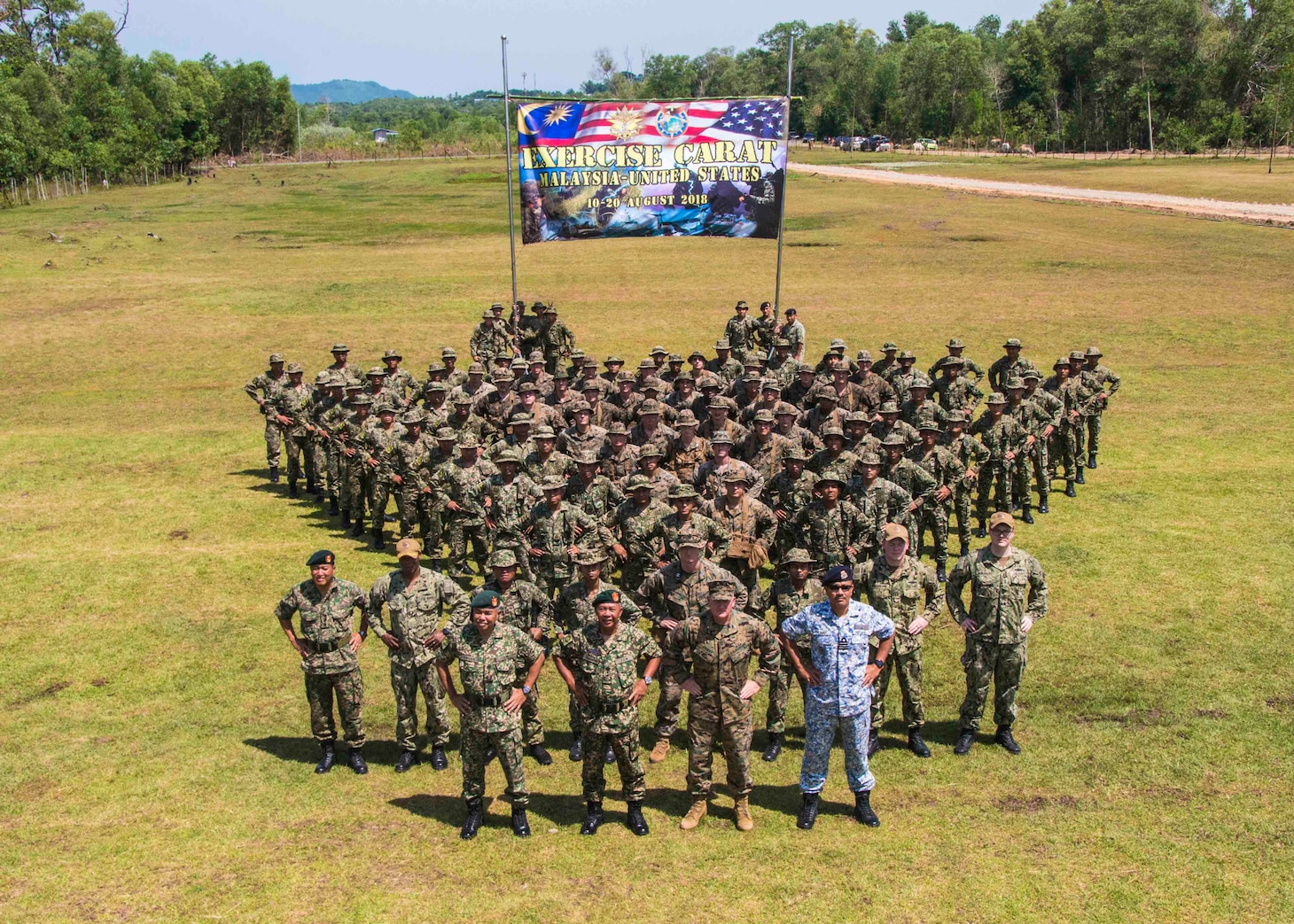 KOTA KINABALU, Malaysia (August 10, 2018) - U.S. Marines stand in formation with Marines from the Royal Malaysian Navy for a photo during the opening ceremony of Cooperation Afloat Readiness and Training (CARAT) Malaysia on Kota Belud Marine Base. CARAT Malaysia in its 24th iteration, is designed to enhance information sharing and coordination, build mutual warfighting capability and support long-term regional cooperation enabling both partner armed forces to operate effectively together as a unified maritime force.