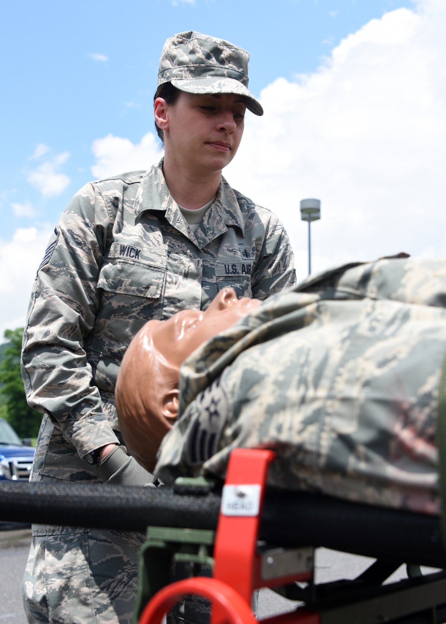 Master Sgt. Christina Wick, a Medical Technician from the Pittsburgh International Airport Air Reserve Station, assists taking the mannequin on a stretcher off of the NATO Gurney and onto the ground in an exercise at Camp Dawson, West Virginia June 19, 2018. Wick was working with a team to practice for an obstacle course later on. (U.S. Air Force Photo by Senior Airman Grace Thomson)