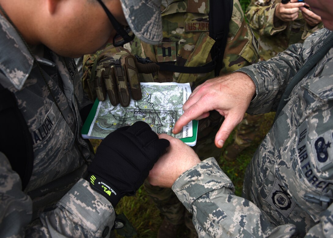 Senior Airman Anthony Walden, a medical technician from the Aeromedical Staging Squadron, Capt. Sarah May, a Flight nurse with the Aeromedical Evacuation Squadron, and Tech. Sgt. Stephen Welch, a Security Forces Squadron member, all from the Pittsburgh International Airport Air Reserve Station, attempt to find their position on the map at Camp Dawson, West Virginia June 21, 2018. Each member had been through training and this was their chance to put it into practice.
(U.S. Air Force Photo by Senior Airman Grace Thomson)