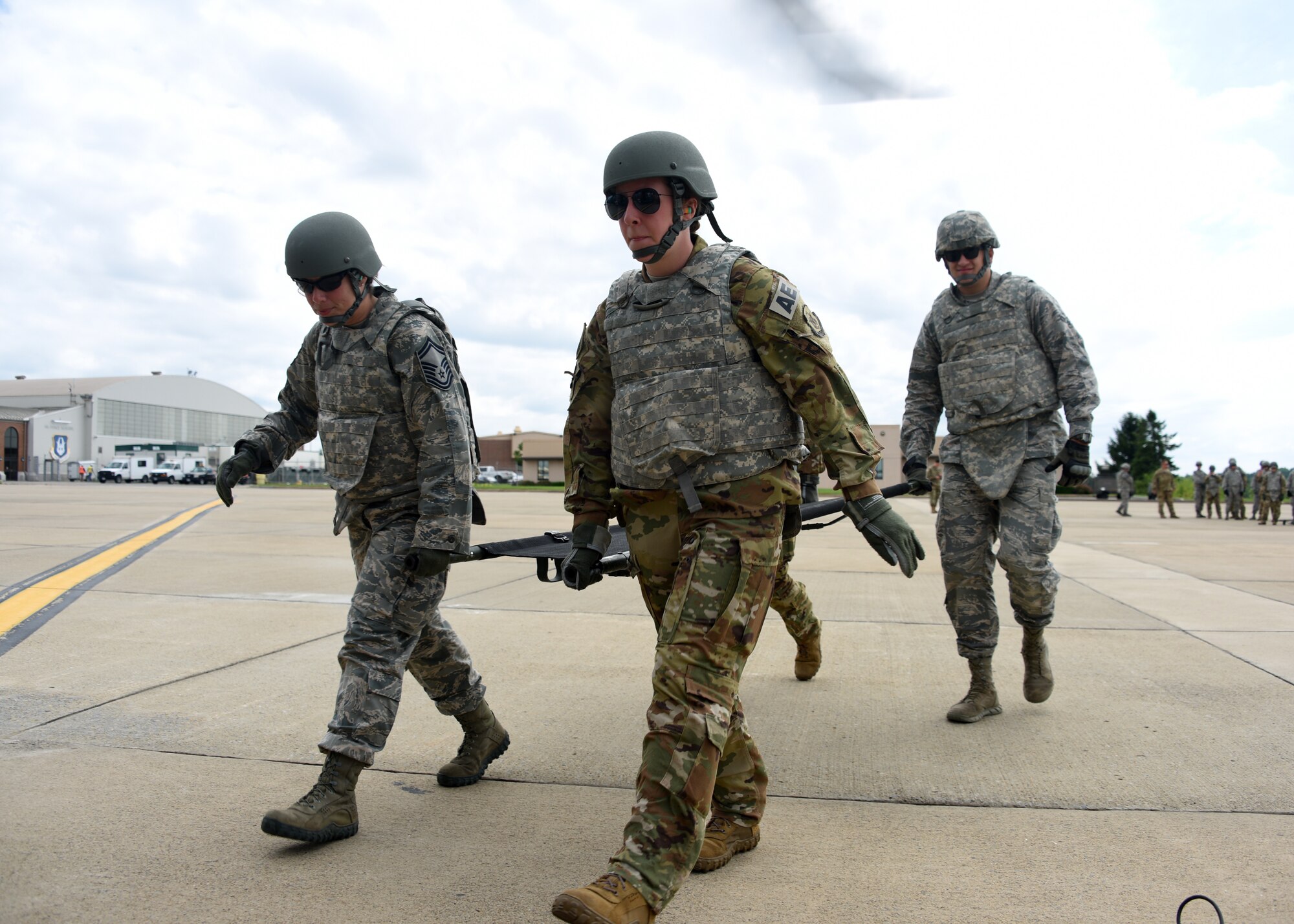 Senior Master Sgt. Winland of the Aeromedical Staging Squadron from the Pittsburgh International Airport Air Reserve Station, Senior Airman Jordan Kinley, First Lt. Danielle Miller, and Senior Airman Dakota Luknis from the Aeromedical Evacuation Squadron at the Pittsburgh International Airport Air Reserve Station carry a stretcher to a Blackhawk helicopter at the Pittsburgh International Airport Air Reserve Station, Pennsylvania, June 26, 2018. Members from the squadrons were split into teams so that each member would have a chance to work with the helicopter as well as people from the other Squadron. (U.S. Air Force Photo by Senior Airman Grace Thomson)