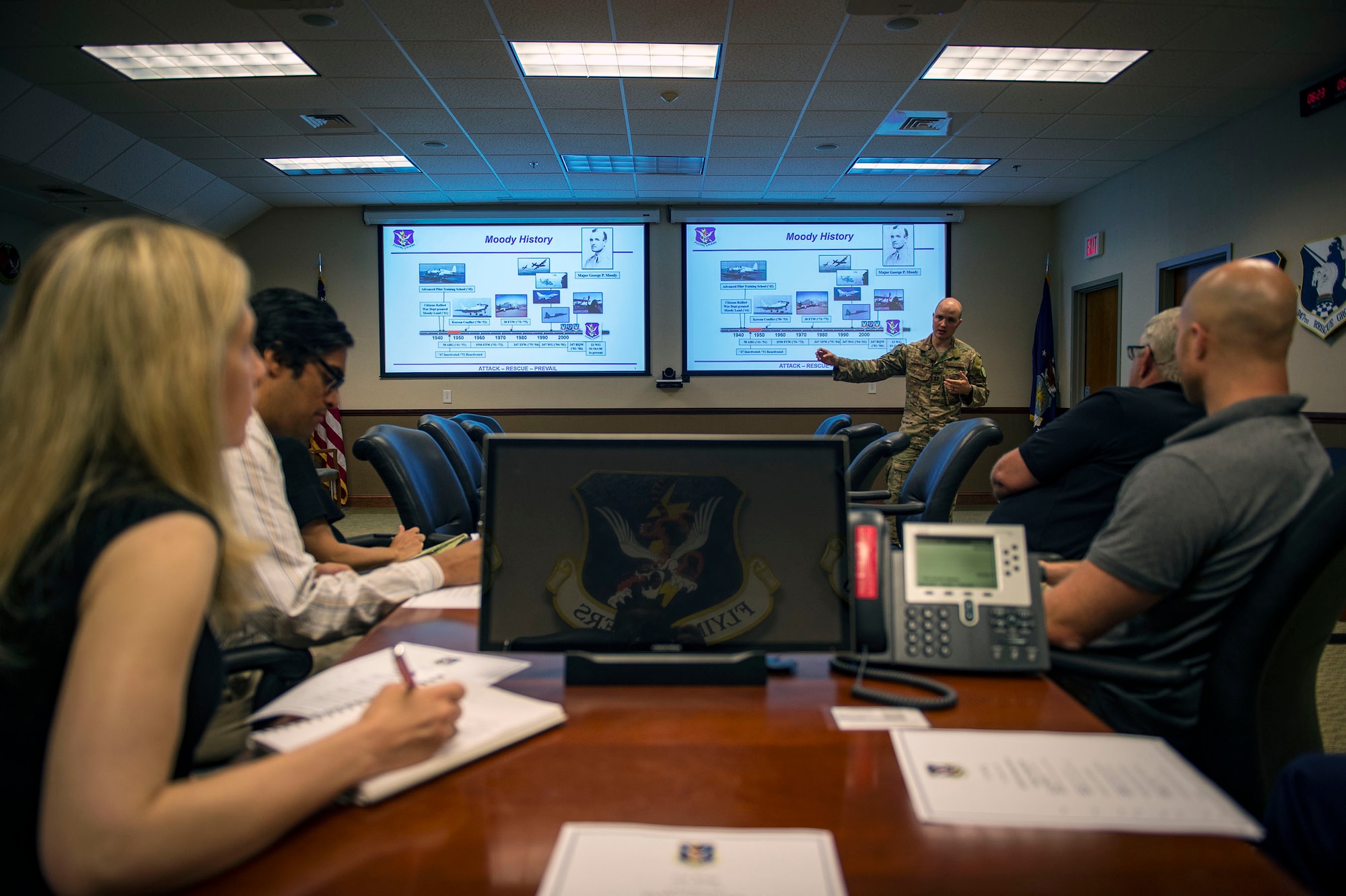 Capt. Bobby Theologis, 23d Wing executive officer, briefs Moody’s mission capabilities to analysts from the RAND Corporation during a visit, Aug. 7, 2018, at Moody Air Force Base, Ga. RAND integrated with Moody’s rescue, flying and maintenance professionals to examine firsthand Air Force operations. This familiarization helps RAND develop their analysis to ultimately present policy recommendations to Air Force decision makers. Since 1948, RAND has performed analysis for the U.S. Air Force. (U.S. Air Force photo by Senior Airman Greg Nash)