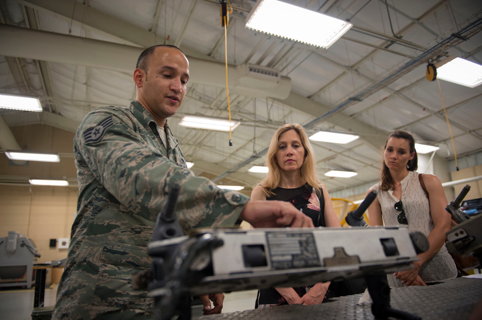 Staff Sgt. Brian Crews, left, 23d Maintenance Squadron alternate munitions equipment element supervisor, shows the functions of a mount rack for analysts from the RAND Corporation during a visit, Aug. 8, 2018, at Moody Air Force Base, Ga. RAND integrated with Moody’s rescue, flying and maintenance professionals to examine firsthand Air Force operations. This familiarization helps RAND develop their analysis to ultimately present policy recommendations to Air Force decision makers. Since 1948, RAND has performed analysis for the U.S. Air Force. (U.S. Air Force photo by Senior Airman Greg Nash)