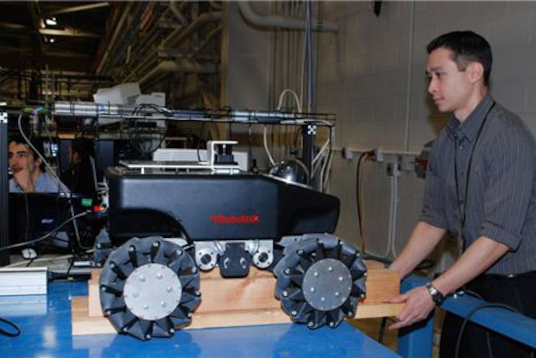 A Navy engineer raises a robot onto blocks.