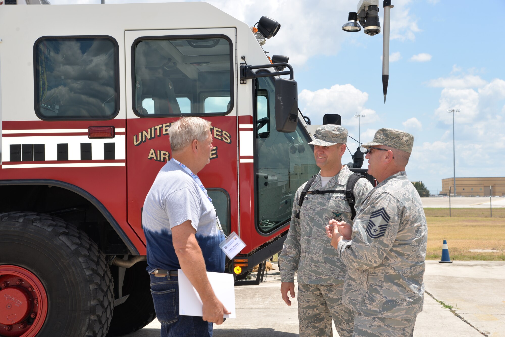 Dale Johnson, DLJ Commercial Roofing owner, talks with Master Sgt. Stephen M. Johnson, 433rd Civil Engineering Squadron assistant fire chief, and Chief Master Sgt. Robert M. Clarkin, 433rd Civil Engineering Squadron fire chief, about firefighting with an Oshkosh Striker aircraft rescue and firefighting vehicle at Joint Base San Antonio-Lackland, Texas Aug. 4, 2018. (U.S. Air Force photo by Master Sgt. Kristian Carter