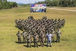 U.S. Marines stand in formation with Marines from the Royal Malaysian Navy for a photo during the opening ceremony of Cooperation Afloat Readiness and Training on Kota Belud Marine Base, Malaysia.