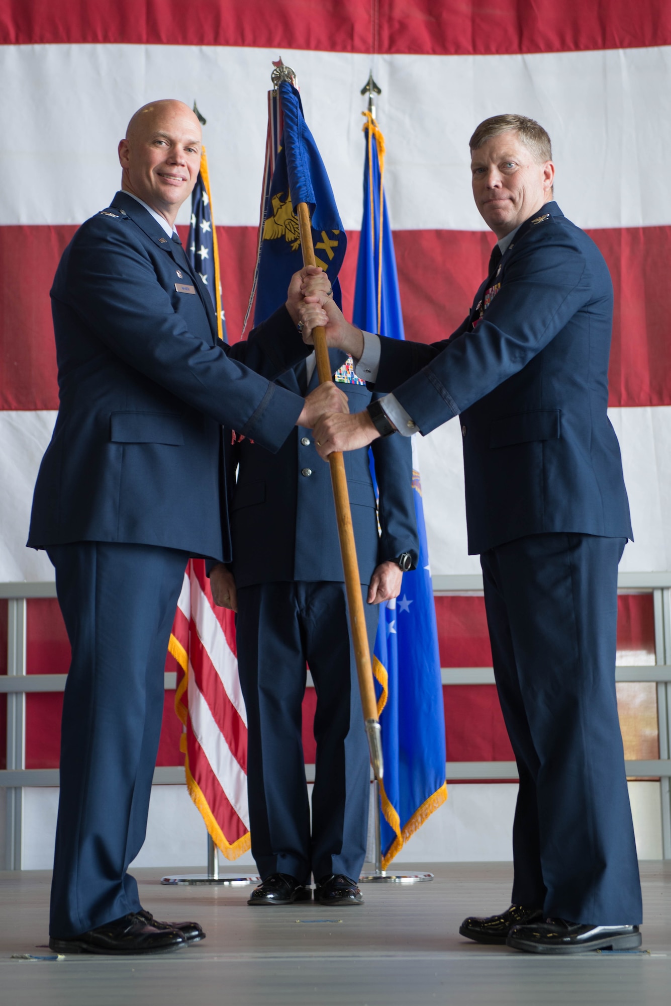 U.S. Air Force Col. Michael Manion, 55th Wing commander, left, presents accepts the guidon of the 55th Maintenance Group (MXG) to from U.S. Air Force Col. Clayton Seale, the outgoing 55th MXG commander, during a change of command ceremony July 25, 2018, at Offutt Air Force Base (AFB), Nebraska. Seale led 1,200 personnel responsible for providing maintenance to 33 aircraft and all transient aircraft equipment for Offutt AFB. (U.S. Air Force photo by Zachary Hada)