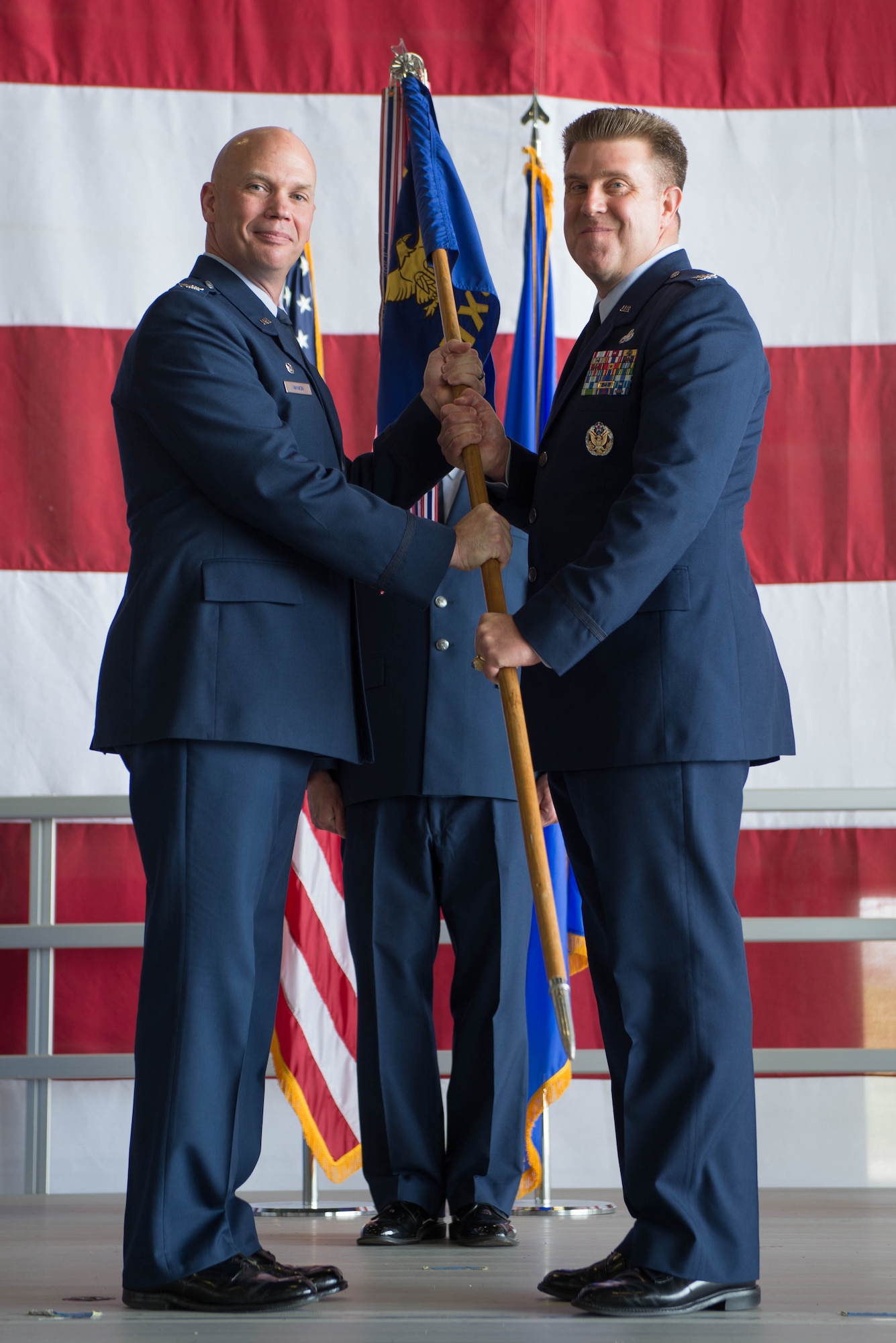 U.S. Air Force Col. Michael Manion, 55th Wing commander, left, presents the guidon of the 55th Maintenance Group (MXG) to U.S. Air Force Col. Todd Hammond, the incoming 55th MXG commander, during a change of command ceremony July 25, 2018, at Offutt Air Force Base (AFB), Nebraska. The 55th MXG has operational control of three squadrons and provides centralized direction of all maintenance staff functions for Offutt AFB. (U.S. Air Force photo by Zachary Hada)