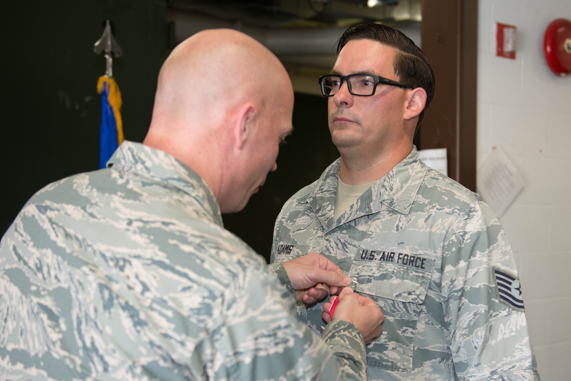 U.S. Air Force Col. Michael Manion, 55th Wing commander, pins a Bronze Star Medal to Tech. Sgt. William Adams, 55th Strategic Communications Squadron tactical radio supervisor, Aug. 7, 2018, at Offutt Air Force Base, Nebraska. Adams was awarded the Bronze Star Medal for meritorious achievement during a yearlong deployment at Kandahar Airfield, Afghanistan. (U.S. Air Force photo by Zachary Hada)