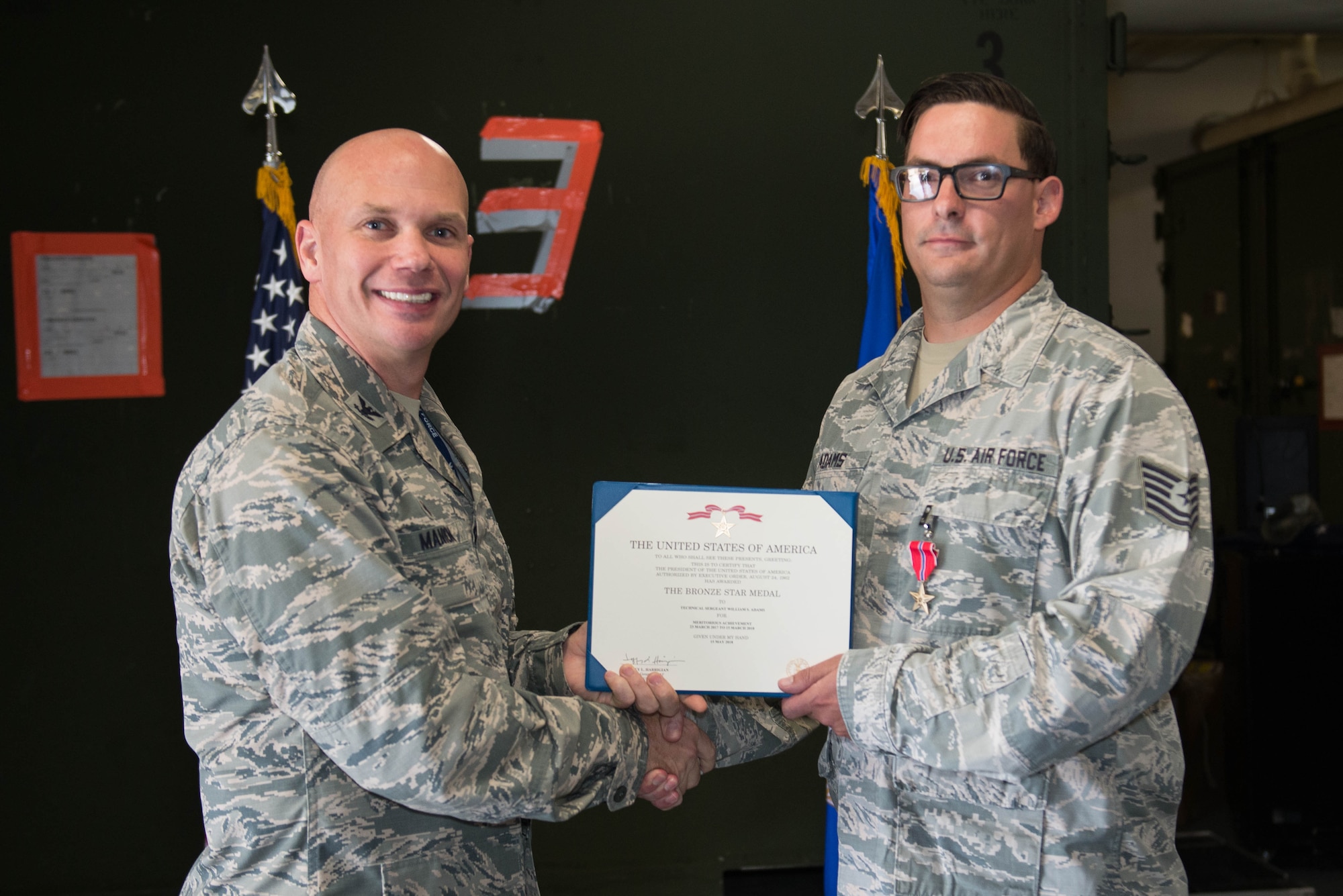 U.S. Air Force Col. Michael Manion, 55th Wing commander, presents a Bronze Star Medal certificate to Tech. Sgt. William Adams, 55th Strategic Communications Squadron tactical radio supervisor, Aug. 7, 2018, at Offutt Air Force Base, Nebraska. The Bronze Star Medal is a United States decoration awarded to members of the U.S. armed forces for heroic achievement, heroic service, meritorious achievement, or meritorious service in a combat zone. (U.S. Air Force photo by Zachary Hada)