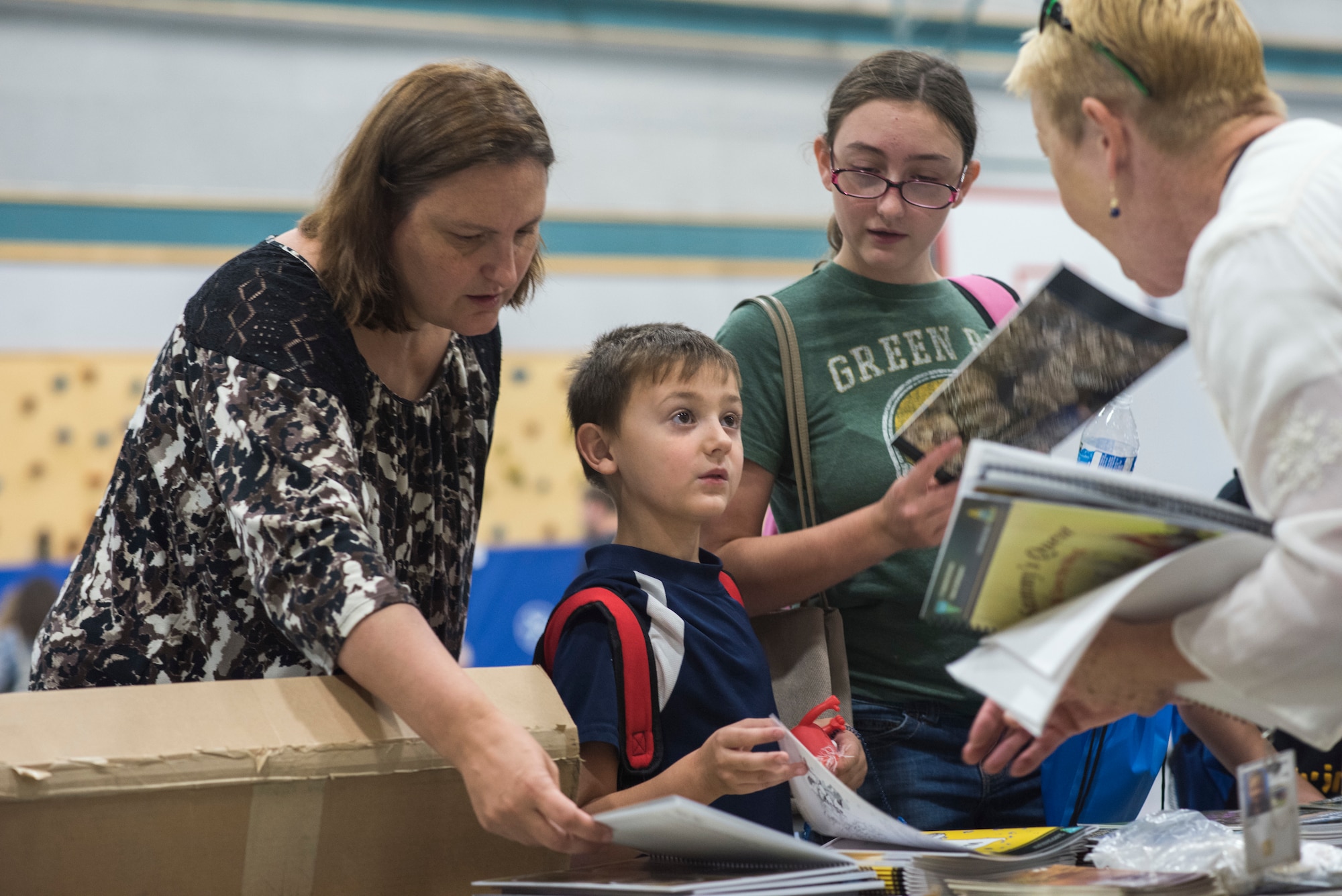 A child receives information from a Bureau of Land Management representative during the Back to School Brigade Aug. 4, 2018, at Mountain Home Air Force Base, Idaho. The Back to School Brigade event provided backpacks filled with supplies to 200 military children.