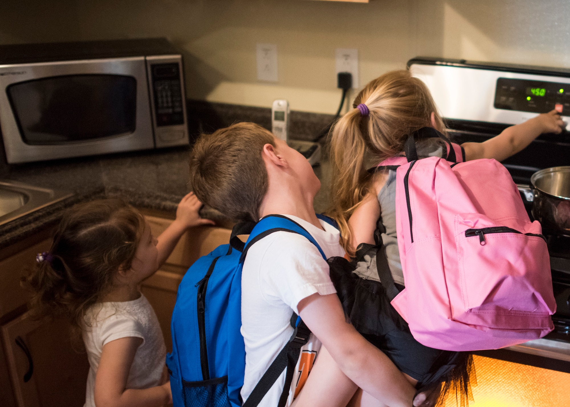 Children shut off an oven during a fire safety training Aug. 4, 2018, at Mountain Home Air Force Base, Idaho. The base firefighters brought their fire prevention trailer to teach children and families what to do during kitchen and bedroom fires.