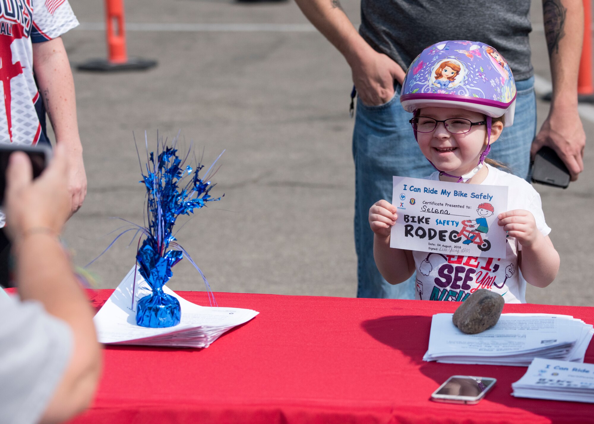 A child poses for a photo with her certificate after completing the bicycle safety course Aug. 4, 2018, at Mountain Home Air Force Base, Idaho. The bicycle safety course gave children the opportunity to practice handsignals and that they should walk their bikes across the road when using a crosswalk.