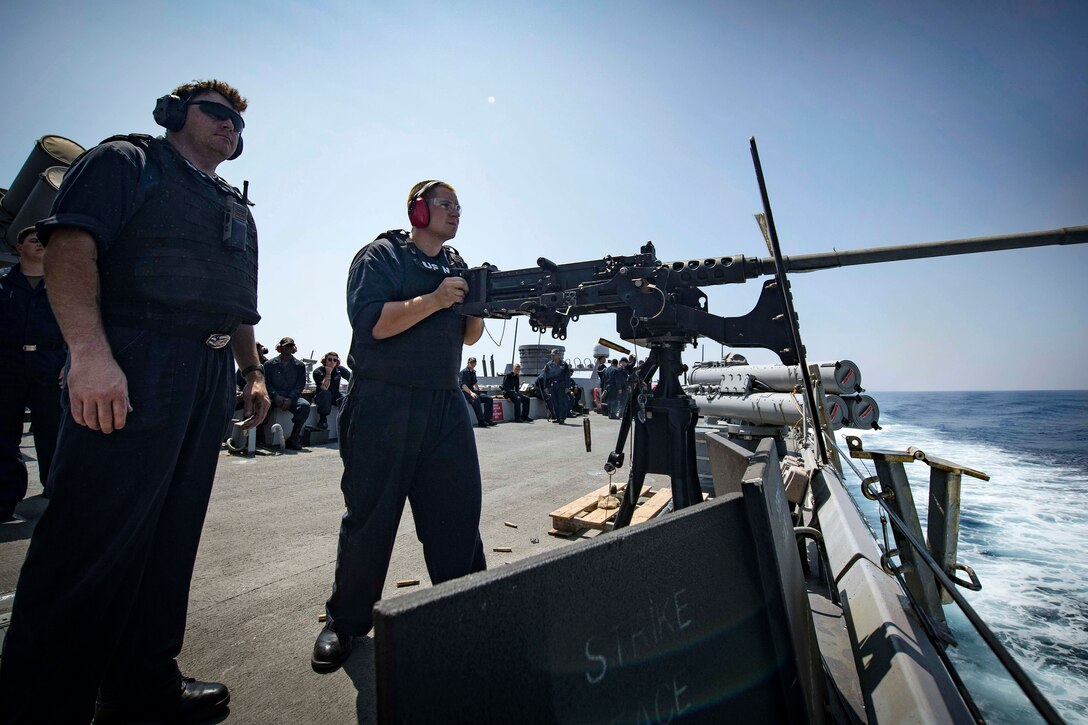 A sailor prepares to fire a .50-caliber machine gun during live-fire training.