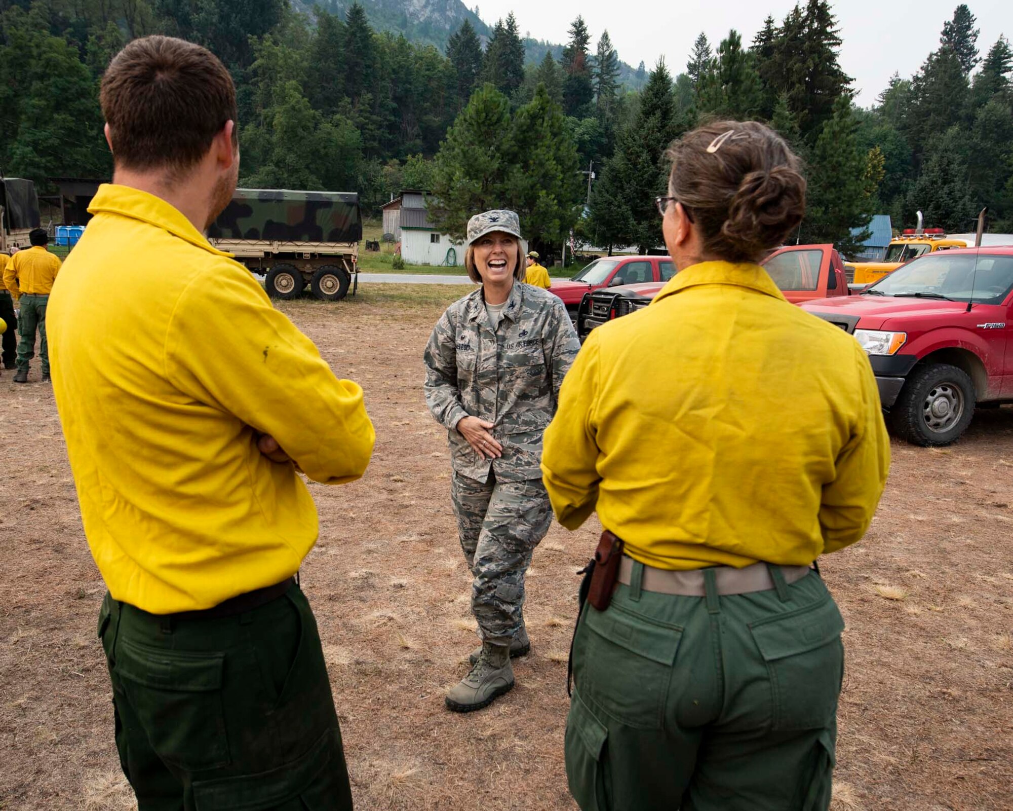 Col. Lisa McLeod, commander of the 141st Maintenance Group, laughs with Guardsmen from the 141st Air Refueling Wing while visiting the Sheep Creek fire camp in Northport, Wash. August 8, 2018. Nearly 200 Air and Army National Guardsmen were mobilized to help aid in firefighting efforts throughout Washington State. (U.S. Air National Guard photo by Staff Sgt. Rose M. Lust)