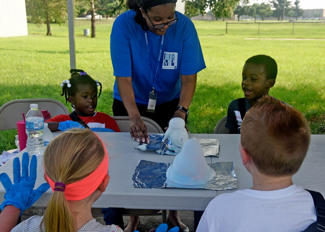 Master Sgt. Crystal Cunningham, 89th Operations Support Squadron mission operations flight chief, helps kids with a science experiment during the 7th Annual Exceptional Family Member Program Summer Camp Experience at Joint Base Andrews, Md., Aug. 7, 2018. Campers were guided through a week of STEM activities by a group of active-duty Air Force and Navy volunteers. (U.S. Air Force photo by Senior Airman Abby L. Richardson)
