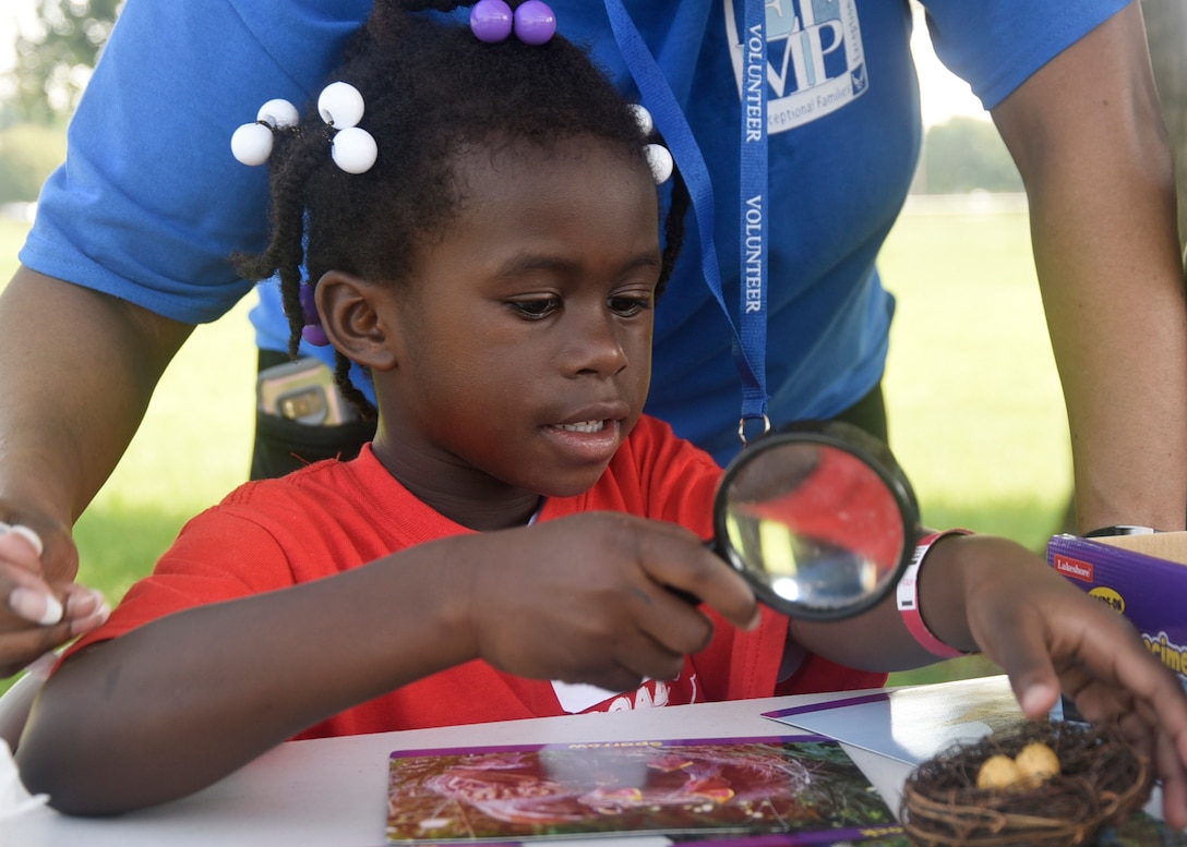 Gabrielle Scott examines objects with a magnifying glass during the 7th Annual Exceptional Family Member Program Summer Camp Experience at Joint Base Andrews, Md., Aug. 7, 2018. The camp focused on STEM-related activities and culminated in a field trip to the Smithsonian National Air and Space Museum in Washington, D.C. (U.S. Air Force photo by Senior Airman Abby L. Richardson)
