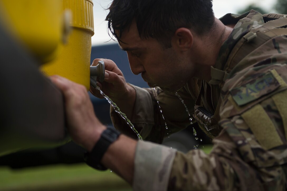 1st Lt. Andrew Janosick, 20th Air Support Operations Squadron (ASOS) joint terminal attack controller (JTAC), drinks water after a ruck march during Draco Spear, Aug. 3, 2018, at Moody Air Force Base, Ga. Draco Spear is a revival of the mid-2000s joint-training event Dragon Challenge that tested the top JTACs from various air support operations squadrons both mentally and physically. (U.S. Air Force photo by Senior Airman Janiqua P. Robinson)