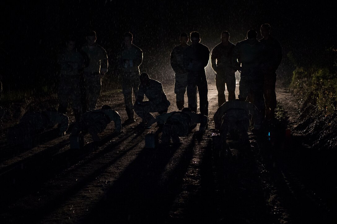 Joint terminal attack controllers from the 18th Air Support Operations Group perform push-ups before sunrise during Draco Spear, Aug. 3, 2018, at Moody Air Force Base, Ga.Draco Spear is a revival of the mid-2000s joint-training event Dragon Challenge that tested the top JTACs from various air support operations squadrons both mentally and physically. (U.S. Air Force photo by Senior Airman Janiqua P. Robinson)
