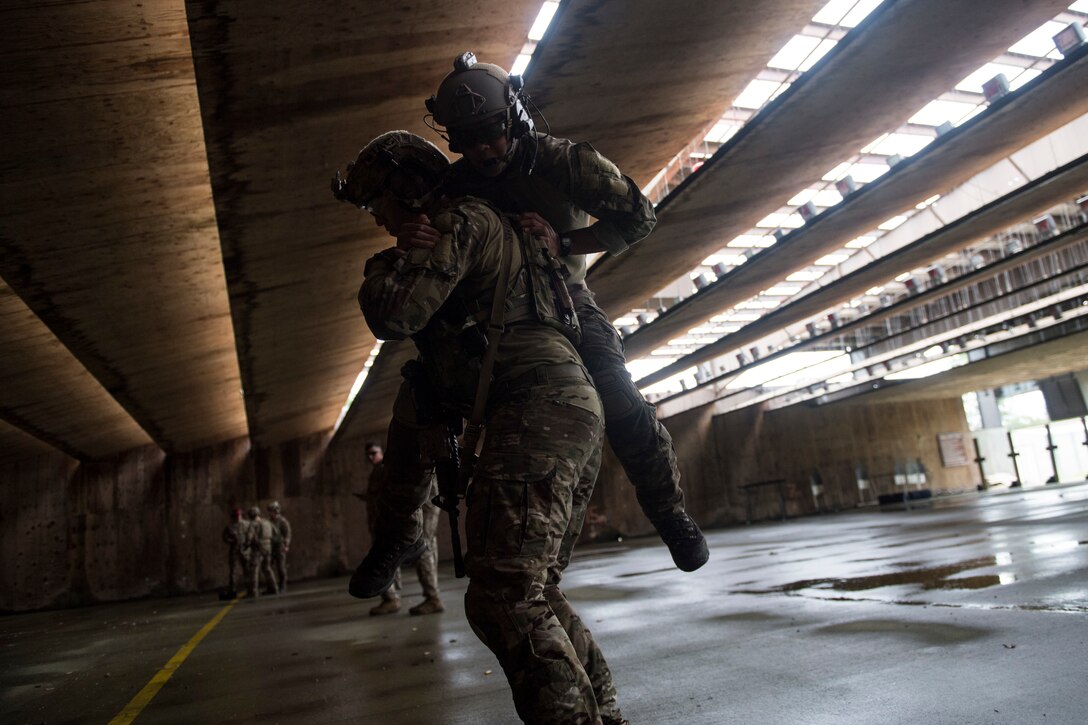 A joint terminal attack controller (JTAC) from the 18th Air Support Operations Group carries a fellow JTAC during Draco Spear, Aug. 3, 2018, at Moody Air Force Base, Ga. Draco Spear is a revival of the mid-2000s joint-training event Dragon Challenge that tested the top JTACs from various air support operations squadrons both mentally and physically. (U.S. Air Force photo by Senior Airman Janiqua P. Robinson)