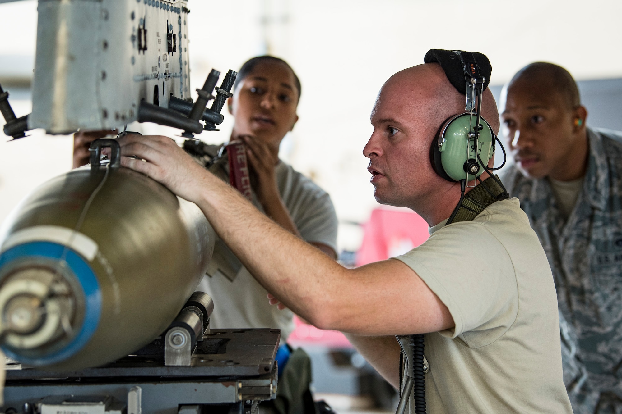 Staff Sgt. Jeff Atha, center, 23d Aircraft Maintenance Squadron weapons load crew chief, inspect a bomb during a Monthly Proficiency Required Load (MPRL), Aug. 7, 2018, at Moody Air Force Base, Ga. The weapons standardization section ensures weapons load crews are combat ready through evaluations consisting of MPRLs, semi-annual evaluations and flightline inspections. (U.S. Air Force photo by Airman Taryn Butler)