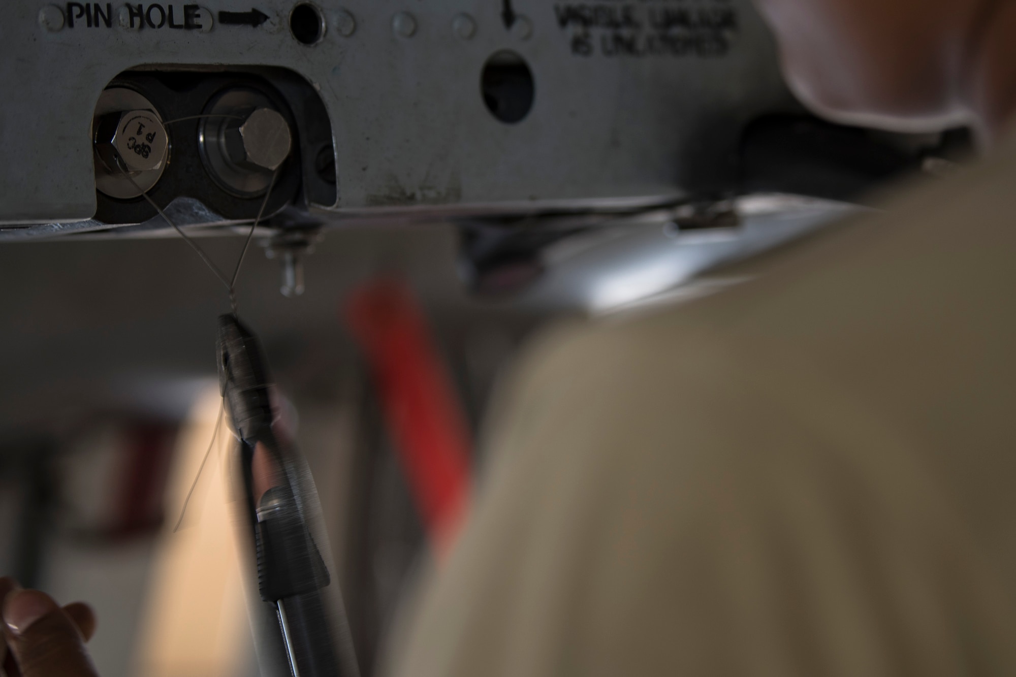 Airman 1st Class Kenyah Smith, 23d Aircraft Maintenance Squadron weapons load crew member, twists a wire during a Monthly Proficiency Required Load (MPRL), Aug. 7, 2018, at Moody Air Force Base, Ga. The weapons standardization section ensures weapons load crews are combat ready through evaluations consisting of MPRLs, semi-annual evaluations and flightline inspections. (U.S. Air Force photo by Airman Taryn Butler)