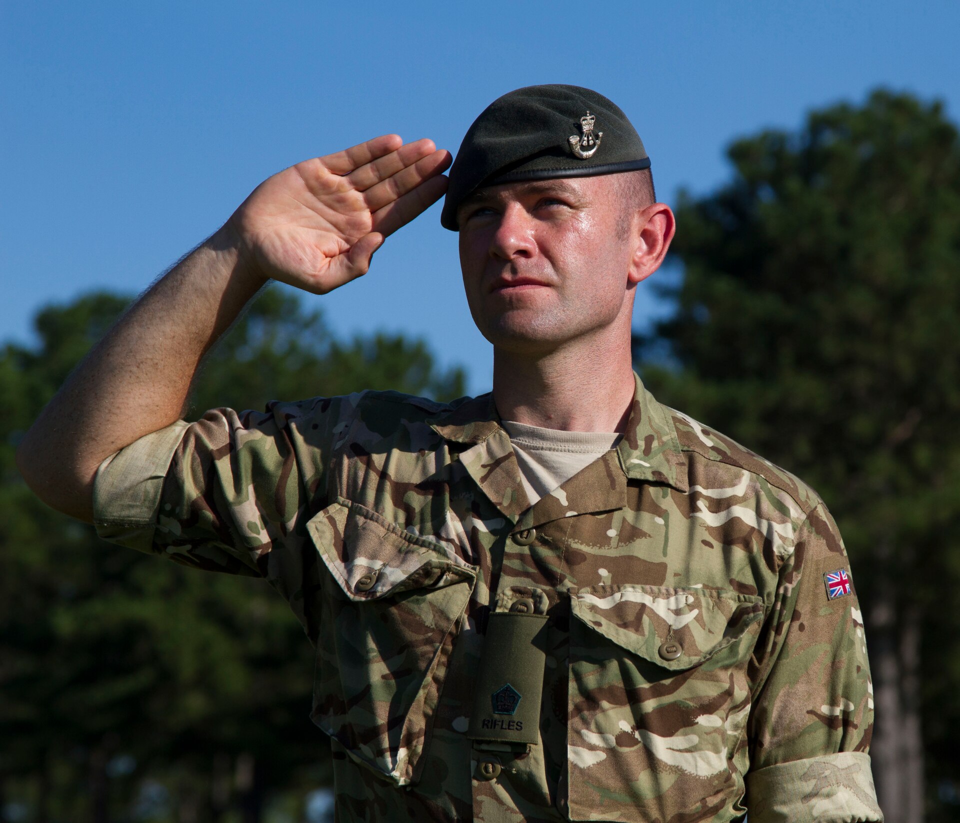 A member of the British Armed Forces honors the national anthems of each participating nation during the opening ceremony of Exercise STEPPE EAGLE 18. Exercise participation strengthens and refines peaceful military-to military relationships and underscores the U.S. committment, and increases interoperability with participating nations.