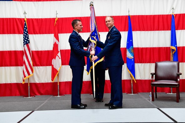 The Western Air Defense Sector Honor Guard post the colors during the WADS assumption of command ceremony at the Washington Army National Guard Readiness Center, Joint Base Lewis-McChord, Washington, July 31, 2018.  The new commander, Col. Gregory Lewis (right), stands beside the presiding officer, Brig. Gen. Kenneth Ekman, First Air Force and Air Forces Northern Command vice commander.