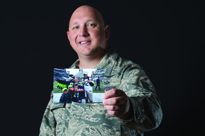 U.S. Air Force Tech. Sgt. Heath Trepanier, a 381st Intelligence Squadron analyst, holds a family photo, one of his most prized possessions, Aug. 7. Trepanier was diagnosed with leiomyosarcoma on Jan. 17, 2017. He continues to surpass the 12-month survival timeline he was given at that time.