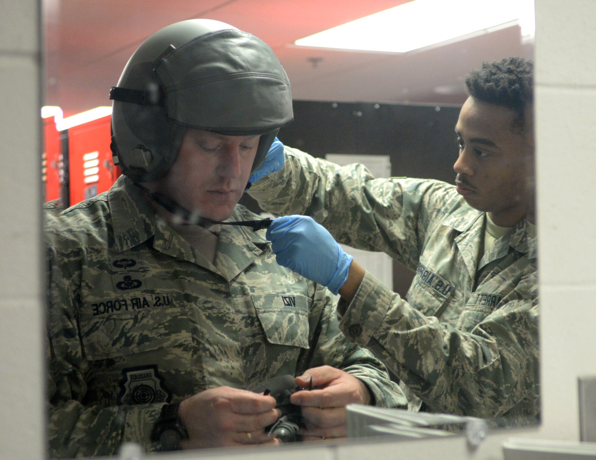 Airman 1st Class Trevor Garrett, a 28th Operations Support Squadron aircrew flight equipment technician, right, fits a helmet for Chief Master Sgt. Adam Vizi, the 28th Bomb Wing command chief, at Ellsworth Air Force Base, S.D., March 14, 2017. AFE technicians are tasked with performing thorough inspections on equipment such as aircrew helmets, oxygen masks and harnesses, as well as making any necessary repairs. (U.S. Air Force photo by Senior Airman Denise Jenson)