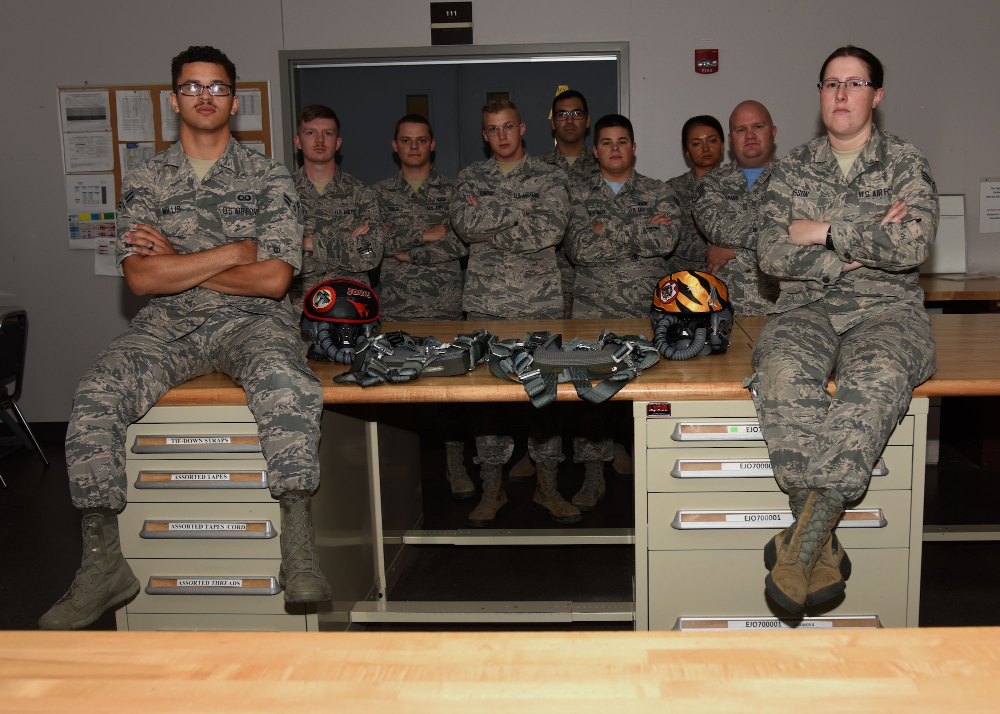 Technicians from 28th Operations Support Squadron aircrew flight equipment shop stand together at Ellsworth Air Force Base, S.D., Aug. 10, 2018. AFE technicians are tasked with performing thorough inspections on equipment such as aircrew helmets, oxygen masks and harnesses, as well as making any necessary repairs. (U.S. Air Force photo by Senior Airman Denise Jenson)
