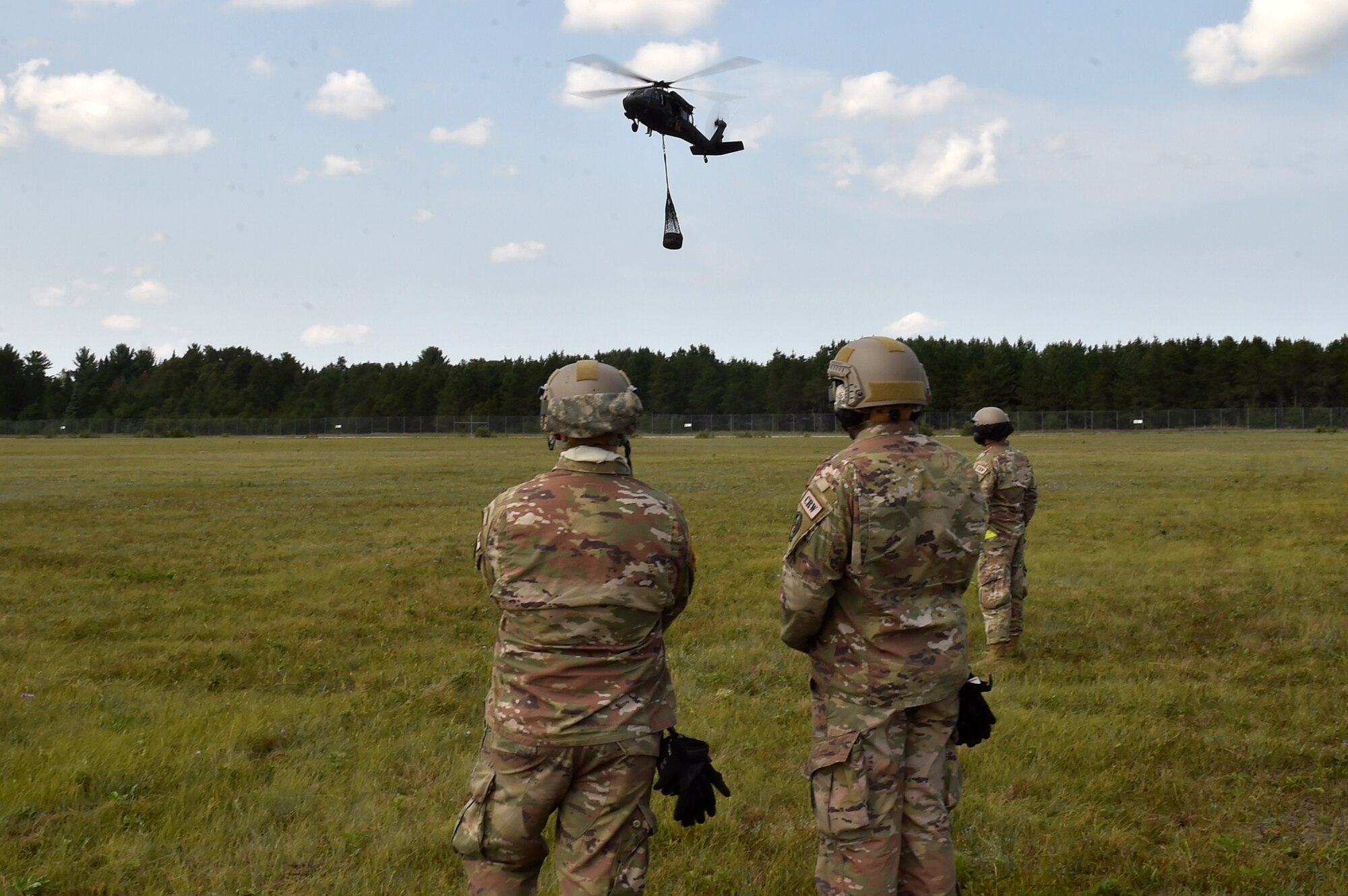 Contingency Response Airmen assigned to the 621st Contingency Response Wing from Travis Air Force Base, Calif., observe a UH-60 Blackhawk helicopter as it carries a load from a cargo pick-up site during sling-load training as part of exercise Northern Strike at Alpena Combat Readiness Training Center, Mich., Aug. 8. Northern Strike is a robust military readiness exercise coordinated by the Michigan Army National Guard which features joint and multi-national militaries working together for total force integration. (U.S. Air Force photo by Tech. Sgt. Liliana Moreno)